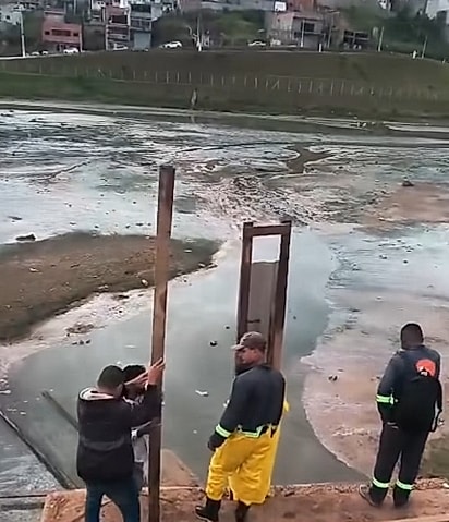 Os trabalhadores utilizaram tábuas de madeira e telhas metálicas para montar uma espécie de ponte.