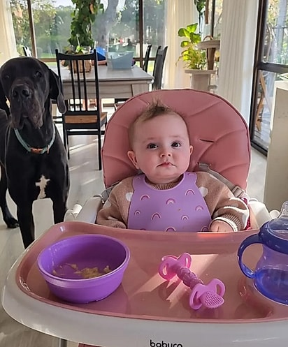 Luci vigiando a garotinha na hora da refeição. 