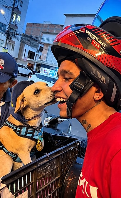 Cachorrinho de boné surpreende jovem com um beijo no rosto durante encontro nas ruas da Colômbia